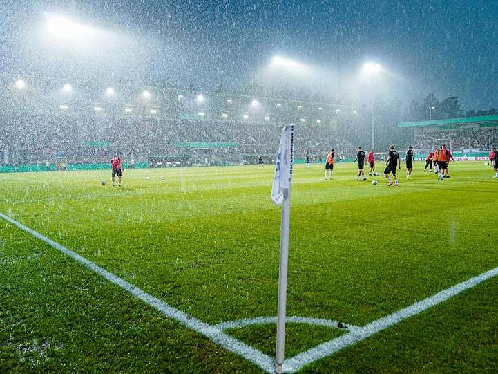 Während der DFB-Pokal-PArtie zwischen dem SV Sandhausen und Borussia Mönchengladbach zieht ein heftiges Gewitter über das Sandhausener Sandhausener Hardtwaldstadion hinweg.