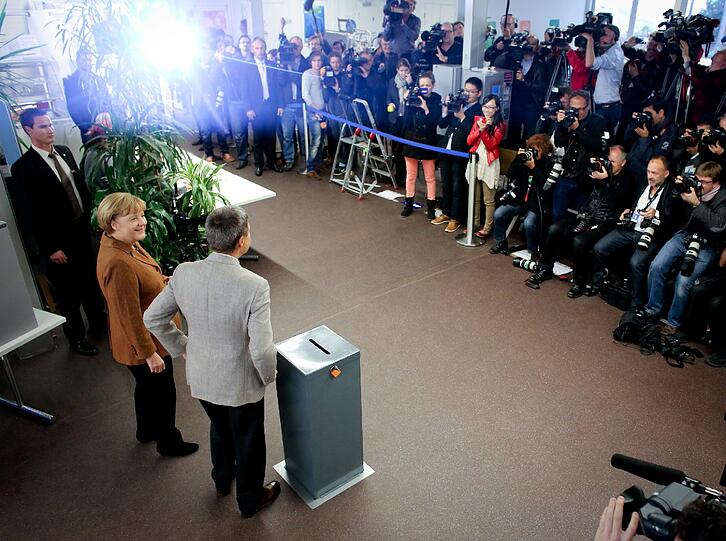 Bundeskanzlerin Angela Merkel (CDU) wirft am 22.09.2013 in Berlin ihren Stimmzettel zur Bundestagswahl 2013 in die Wahlurne.