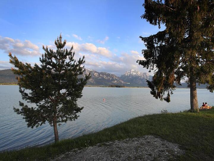 Ausflügler genießen zur Abendstunde den Blick über den Forggensee. Foto: Karl-Josef Hildenbrand/Archivbild