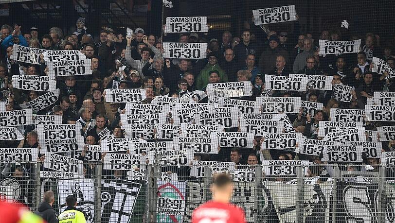 Fans von Wolfsburg protestieren mit Plakaten gegen die Zerstückelung der Spieltage.