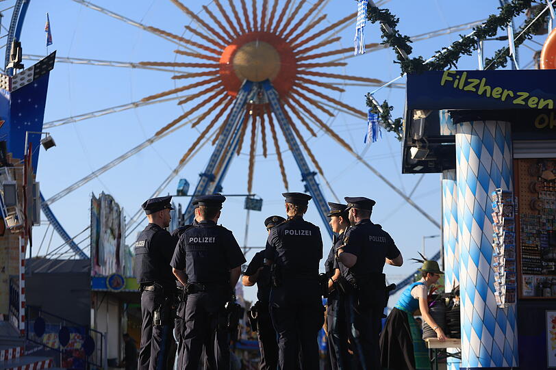 Oktoberfest 2024: Polizisten stehen auf dem Festgelände. Im Hintergrund ist das Riesenrad zu erkennen. Oktoberfest 2024: Polizisten stehen auf dem Festgelände. Im Hintergrund ist das Riesenrad zu erkennen.