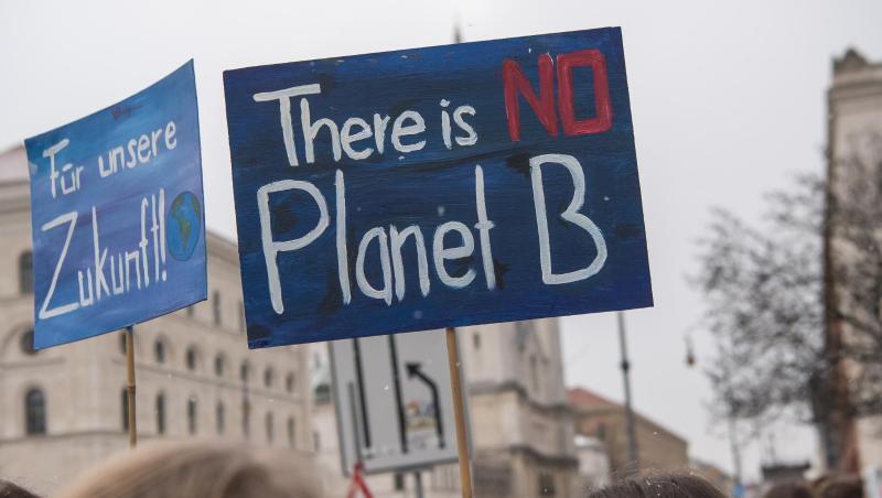 Schüler demonstrieren mit selbstgemalten Plakaten vor der Universität in München für den Klimaschutz. Foto: Peter Kneffel