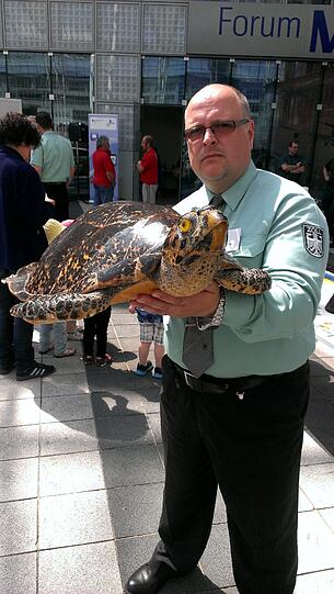 Ein Zollbeamter hält am Flughafen München, am Rande der Jahrespressekonferenz des deutschen Zolls, eine sichergestellte präparierte Karettschildkröte in die Kamera.