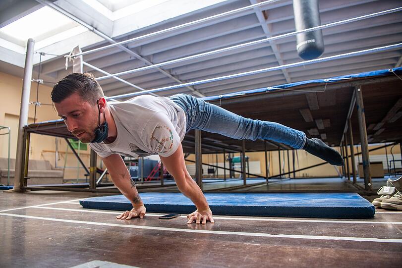 Sven Jahn-Munos, Strapatenartist, macht Streckübungen im Sportraum des Zirkus.