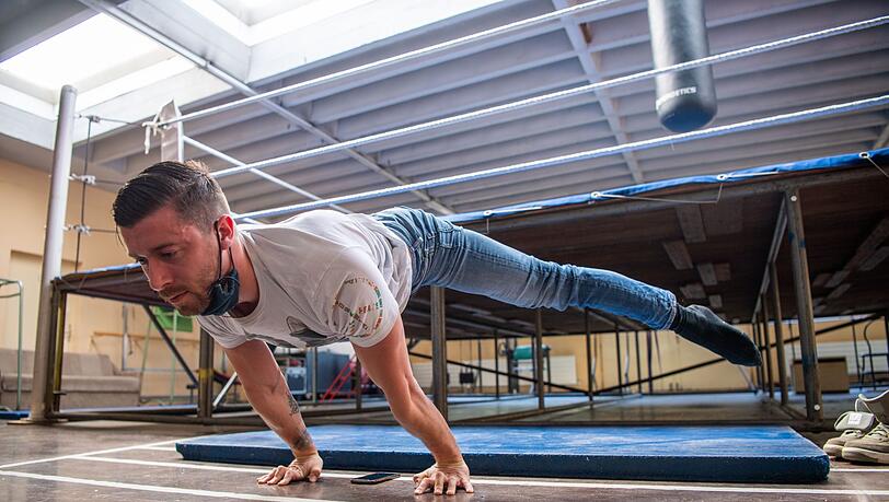 Sven Jahn-Munos, Strapatenartist, macht Streckübungen im Sportraum des Zirkus. Sven Jahn-Munos, Strapatenartist, macht Streckübungen im Sportraum des Zirkus.