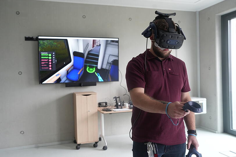 Azubi Flo &uuml;bt mit einer VR-Brille f&uuml;r den Brandfall.