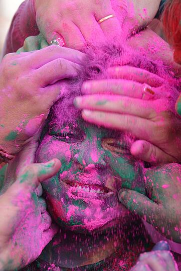 Die Menschen beschmieren sich von oben bis unten mit Farbe, aber besonders viel Spaß macht es, sich die Farbe gegenseitig im Gesicht zu verstreichen.