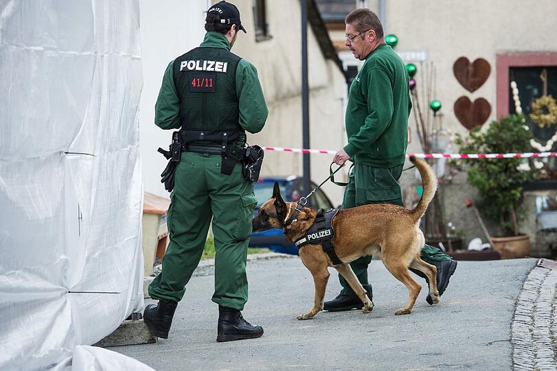 Ein Leichenspürhund wird von der Polizei in einen Hinterhof in Lichtenberg geführt.