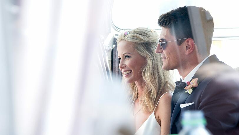 Mario und Carina: Er im dunkelblauen Anzug und mit Sonnenbrille. Sie in Weiß und Blumen im Haar. Mario und Carina: Er im dunkelblauen Anzug und mit Sonnenbrille. Sie in Weiß und Blumen im Haar.