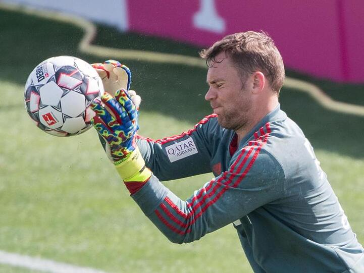 Torwart Manuel Neuer steht während einer Übungseinheit im Tor und fängt einen Ball. Foto: Peter Kneffel/Archiv