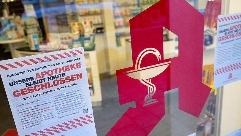 Plakate mit Infos zum bundesweiten Protesttag hängen im Schaufenster einer Apotheke.