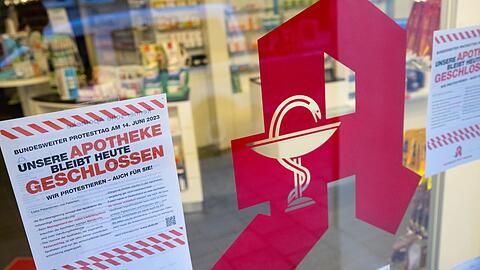 Plakate mit Infos zum bundesweiten Protesttag hängen im Schaufenster einer Apotheke.