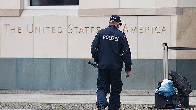 Ein Polizist begutachtet vor der US-Botschaft am Pariser Platz einen verdächtigen Koffer. Ein gewalttätiger Mann ist in Berlin festgenommen worden. Er hatte mit einem Bombenanschlag gedroht. Foto: Paul Zinken/Archiv Ein Polizist begutachtet vor der US-Botschaft am Pariser Platz einen verdächtigen Koffer. Ein gewalttätiger Mann ist in Berlin festgenommen worden. Er hatte mit einem Bombenanschlag gedroht. Foto: Paul Zinken/Archiv