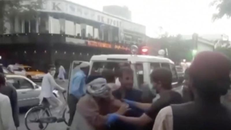 Menschen kümmern sich um eine verwundete Person in der Nähe der Explosion außerhalb des Flughafens in Kabul.