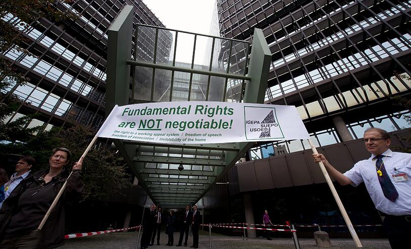 Mitarbeiter des Europäischen Patentamtes (EPA) demonstrieren am 26.06.2013 vor dem Europäischem Patentamt in München auf ihrer Versammlung mit Plakaten für Rede und Vereinigungsfreiheit.