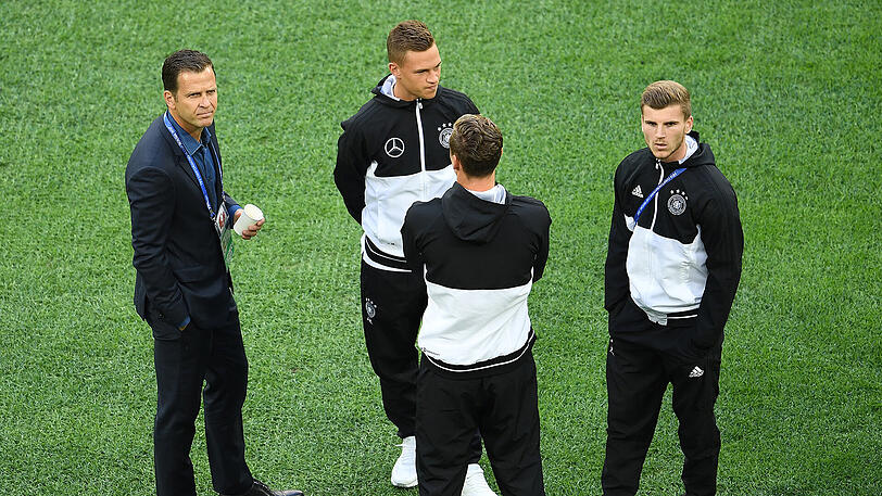 Teammanager Oliver Bierhoff (l-r), Joshua Kimmich und Timo Werner stehen vor dem Spiel auf den Rasen. Beide Spieler stehen in der Startaufstellung.