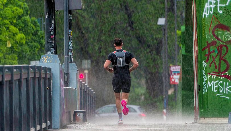 Ein Mann joggt bei strömendem Regen. Ein Mann joggt bei strömendem Regen.