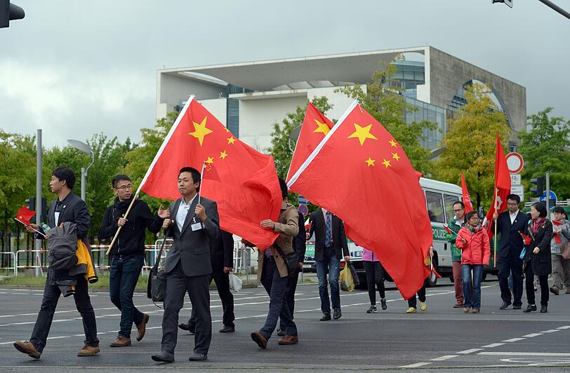 Für den Besuch des chinesichen Ministerpräsidenten gehen Landsleute mit Flaggen und Fähnchen ausgerüstet am 26.05.2013 zu einem Versammlungsplatz gegenüber des Bundeskanzleramtes