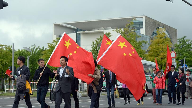 Für den Besuch des chinesichen Ministerpräsidenten gehen Landsleute mit Flaggen und Fähnchen ausgerüstet am 26.05.2013 zu einem Versammlungsplatz gegenüber des Bundeskanzleramtes Für den Besuch des chinesichen Ministerpräsidenten gehen Landsleute mit Flaggen und Fähnchen ausgerüstet am 26.05.2013 zu einem Versammlungsplatz gegenüber des Bundeskanzleramtes