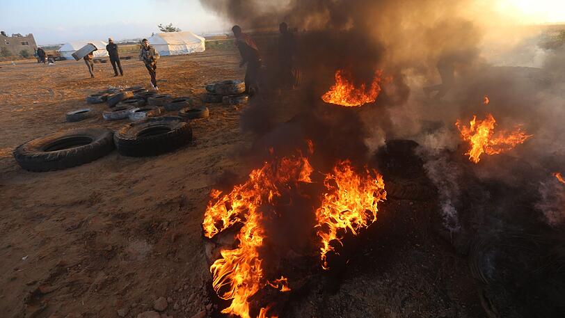 Palästinensische Autonomiegebiete, Khan Younis: Palästinenser versuchen das Feuer zu löschen, das durch Objekte verursacht worden ist, die israelische Drohnen abgeworfen haben.