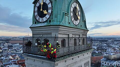 Kräfte der Berufsfeuerwehr München sind am Turm der Kirche St. Peter im Einsatz.