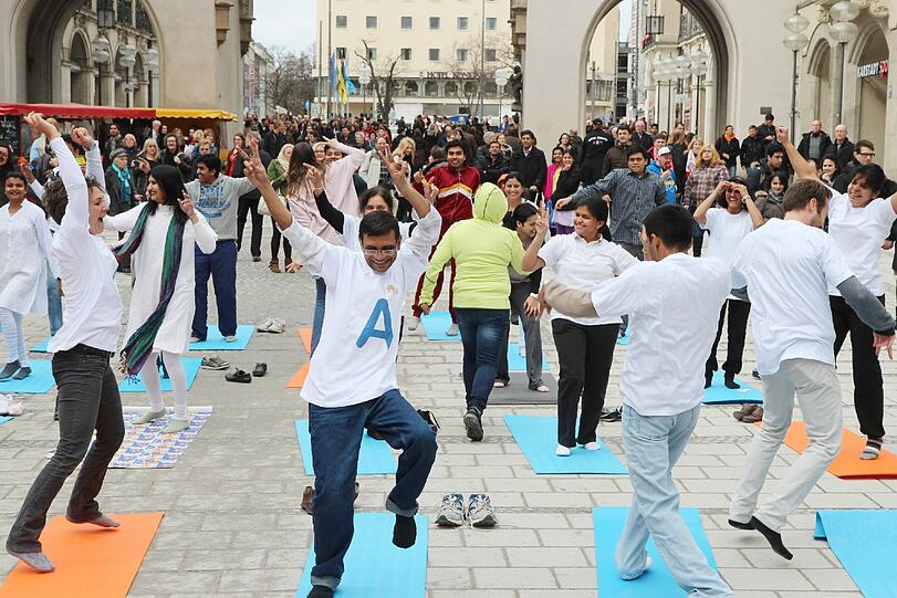 Hopsen und Dehnen in der Fußgängerzone: Am Stachus haben sich Yoga-Fans zu einem Flashmob unter freiem Himmel verabredet. Die Bilder.