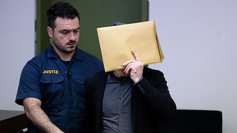 Der wegen des Besitzes und der gewerbsmäßigen Verbreitung kinder- und jugendpornografischer Schriften Angeklagte (r) wird vor Prozessbeginn am Landgericht in den Gerichtssaal geführt.