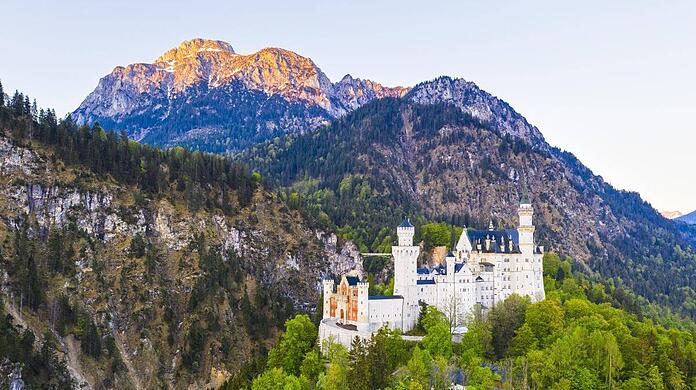 Hinter Neuschwanstein strahlt der Säuling im Morgenlicht.