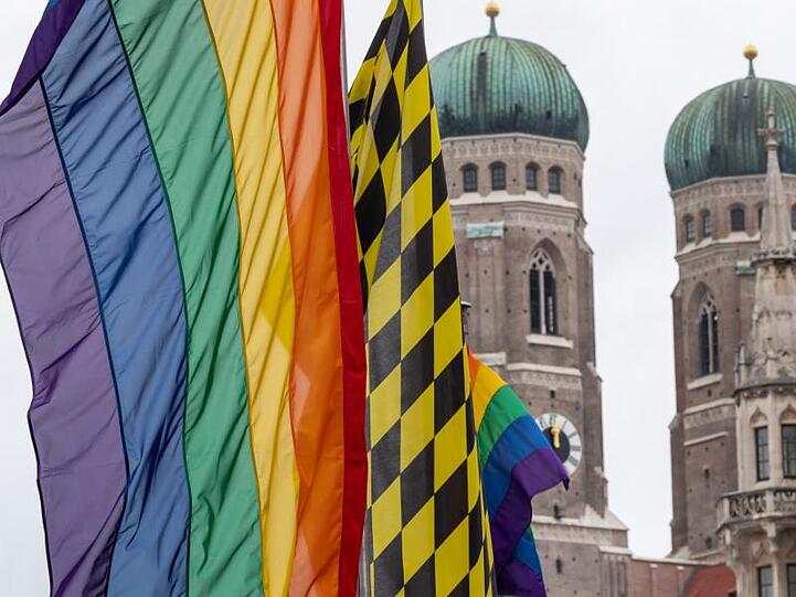 Eine Regenbogenfahne weht vor den Türmen der Münchner Frauenkirche. Foto: Peter Kneffel