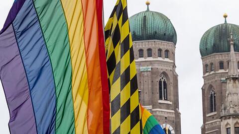 Eine Regenbogenfahne weht vor den Türmen der Münchner Frauenkirche. Foto: Peter Kneffel