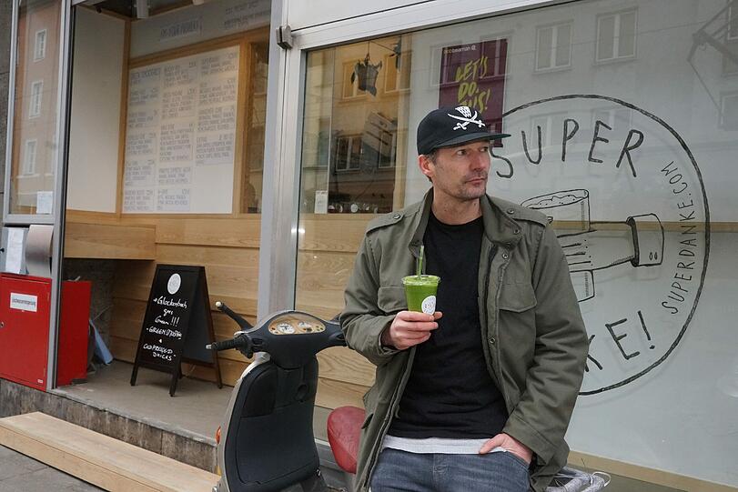 Niels Jäger, Mitgründer des ersten Green Smoothie Spezialisten in Deutschland, entspannt mit Smoothie vor neu eröffneter Super Danke Filiale in Fraunhoferstraße.