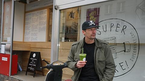 Niels Jäger, Mitgründer des ersten Green Smoothie Spezialisten in Deutschland, entspannt mit Smoothie vor neu eröffneter Super Danke Filiale in Fraunhoferstraße.