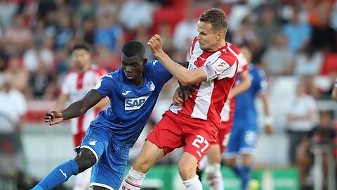 Der Würzburger Sebastian Schuppan (r) kämpft mit dem Hoffenheimer Ihlas Bebou um den Ball.
