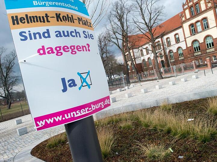 "Helmut-Kohl-Platz" und "Sind Sie auch dagegen" steht auf einem Schild der Bürgerinitiative "Unser Burg".