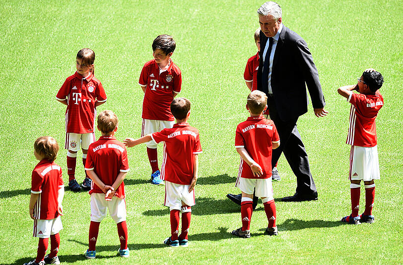 Kinder in Bayern-Trikots stehen auf dem Rasen der Allianz Arena Spalier für den neuen Trainer.