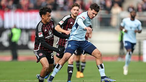 Der Nürnberger Nathaniel Brown (l) kämpft mit William Mikelbrencis vom HSV um den Ball.
