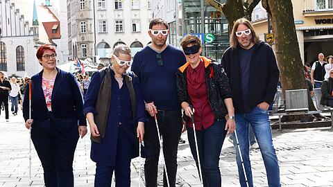 Stefanie Freitag (v.l.n.r.), Leitung Bezirksgruppe München des BBSB, sowie die Stadträte Sofie Langmeier, Stefan Jagel, Barbara Likus und Roland Hefter mit Simulationsbrillen, Schlafmaske und Blindenstock beim Selbstversuch in der Fußgängerzone.