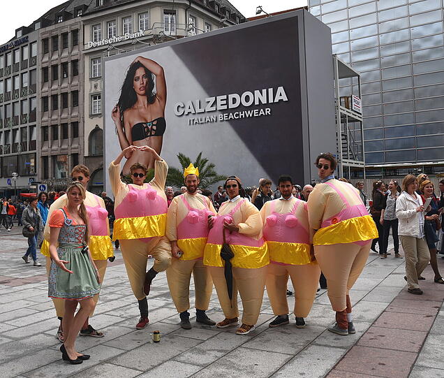 Am Ende werden sie zum Fotomotiv: Passanten scharen sich um die Junggesellen, die sich vor der Calzedonia-Werbung am Marienplatz prächtig amüsieren.