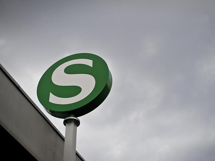 Das Logo der S-Bahn, aufgenommen vor einem dunklen Wolkenhimmel. Foto: Ole Spata/Archivbild