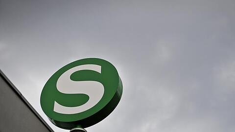 Das Logo der S-Bahn, aufgenommen vor einem dunklen Wolkenhimmel. Foto: Ole Spata/Archivbild
