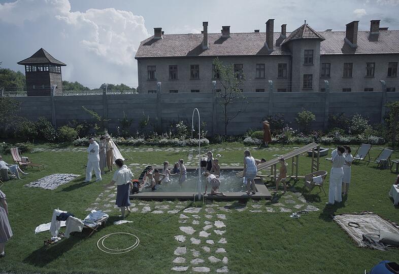Gartenparty bei der Familie Höß, dahinter der Ort des größten Grauens.