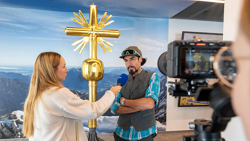 Der Künstler Bernhard Rieger hat das neue Gipfelkreuz geschaffen. Hier wird am Vormittag vor seinem Kunstwerk auf der Zugspitze interviewt.
