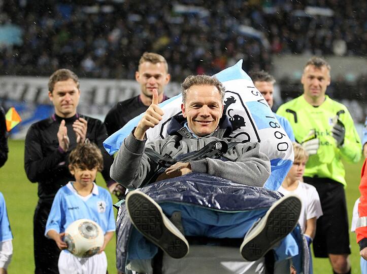 Olaf Bodden wird auf einem Krankenbett auf den Rasen des Grünwalder Stadions gefahren.
