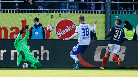 Karlsruhes Torhüter Marius Gersbeck pariert einen Ball von Kiels Fin Bartels (r) - der KSC siegt in Kiel mit 1:0.