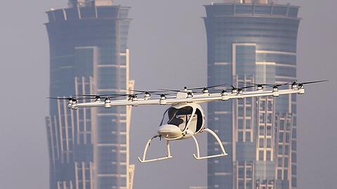 In Ingolstadt startet am Montag ein Modellprojekt zu Flugtaxis. Auf diesem Bild ist ein batteriebetriebener Zweisitzer-Prototyp der deutschen Firma Volocopter zu sehen, der vor der Skyline von Dubai fliegt.