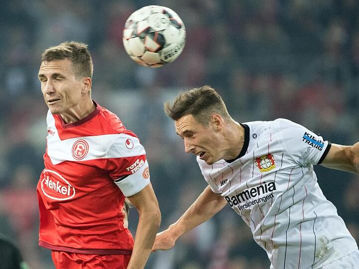 Düsseldorfs Marcel Sobottka (l) und Leverkusens Dominik Kohr kämpfen um den Ball. Foto: Federico Gambarini/Archiv