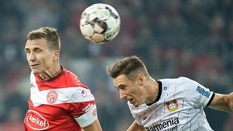 Düsseldorfs Marcel Sobottka (l) und Leverkusens Dominik Kohr kämpfen um den Ball. Foto: Federico Gambarini/Archiv