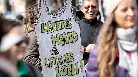 Eine Demonstrantin bringt es in München auf den Punkt: "Letztes Hemd für letztes Loch!"