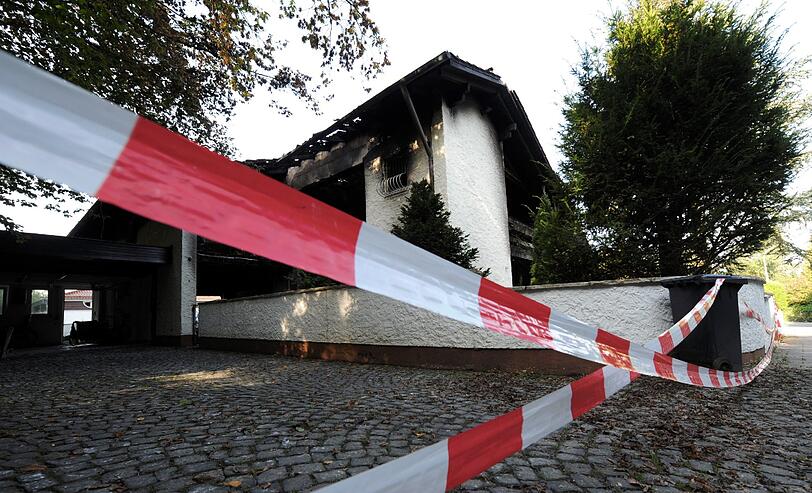 Blick auf die verkohlte Villa des Bayern-Stars Breno: Auch nach Tagen stehen noch Dienstfahrzeuge der Polizei vor dem Anwesen in Grünwald