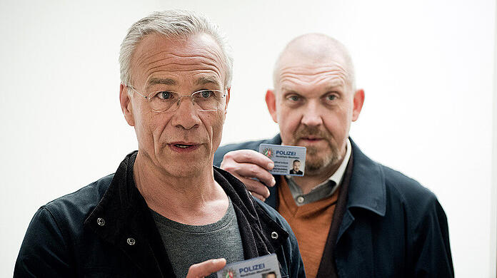 Szene aus dem "Tatort: Bausünden": Die Kommissare Max Ballauf (Klaus J. Behrendt, l.) und Freddy Schenk (Dietmar Bär) weisen sich aus